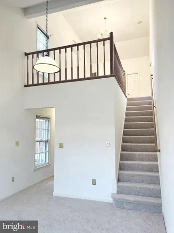 a view of staircase with lots of frames on wall and a window