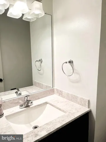 a bathroom with a granite countertop sink and a bathtub