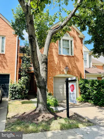 a front view of a house with a yard and tree