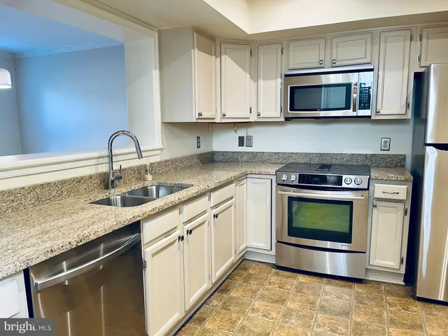 a kitchen with stainless steel appliances granite countertop a sink stove and microwave