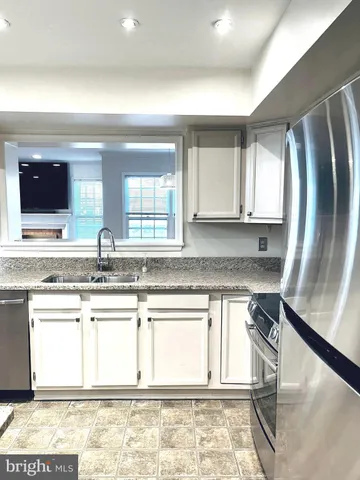 a kitchen with stainless steel appliances granite countertop a sink and a stove