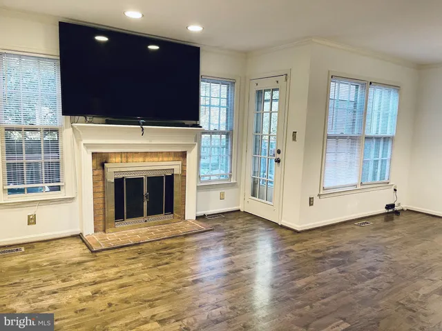 a view of an empty room with a fireplace and a window