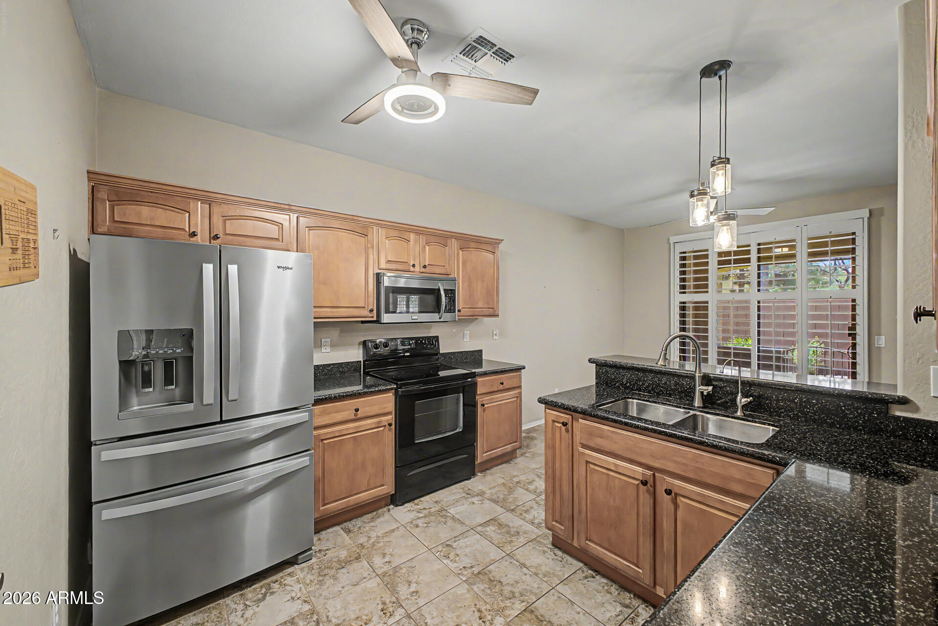 2600 East Springfield Place, Unit 109 Chandler, AZ 85286 - Photo 12 of 38 a kitchen with stainless steel appliances granite countertop a stove and a refrigerator
