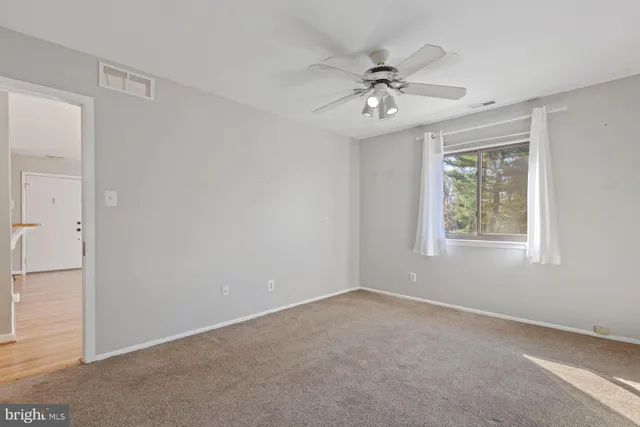 an empty room with a ceiling fan and closet