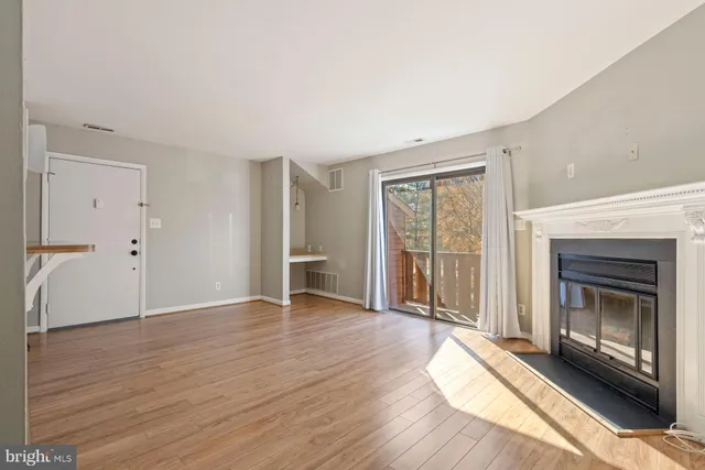 a view of an empty room with a fireplace and a window