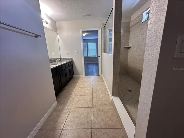 a bathroom with a granite countertop sink a toilet and shower