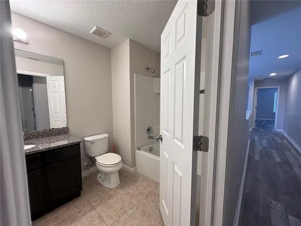 a bathroom with a granite countertop toilet a sink and a mirror