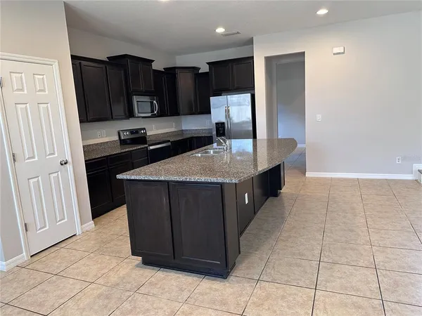 a kitchen with stainless steel appliances granite countertop a refrigerator and a sink