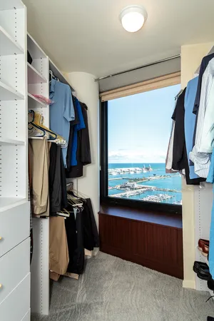 a view of walk in closet with clothes and shoes