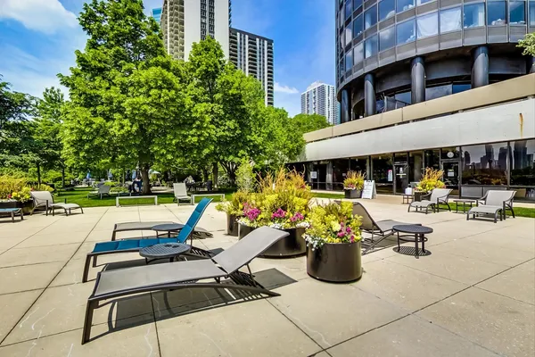 a view of a swimming pool with chairs and tables in patio