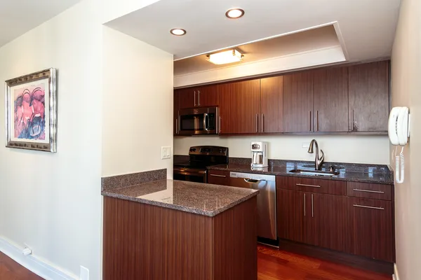 a kitchen with stainless steel appliances granite countertop a sink stove and microwave