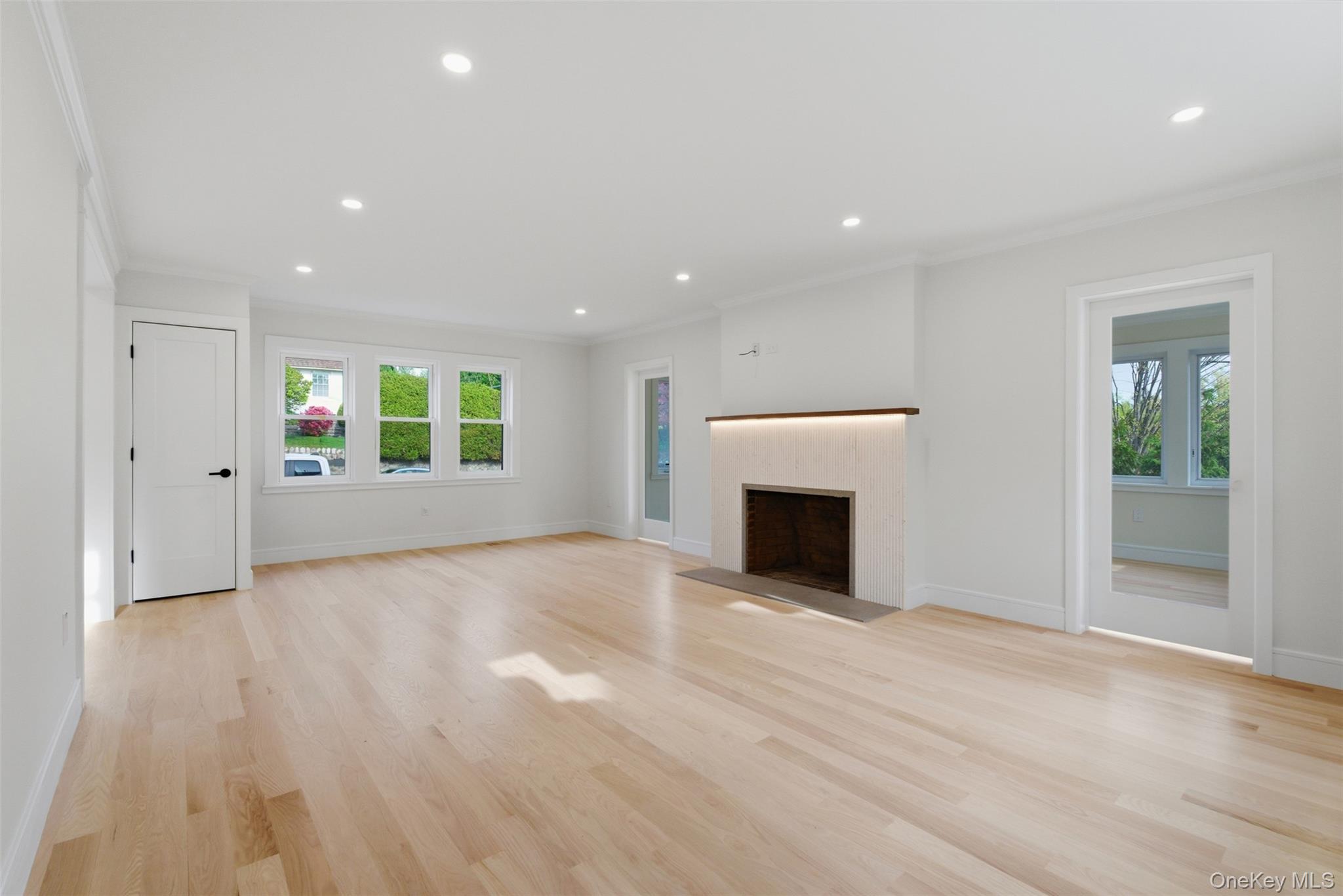 40 Calhoun Avenue New Rochelle, NY 10801 - Photo 13 of 49 Bright living area featuring light wood-finish flooring, recessed lighting, and a modern fireplace with an illuminated mantel