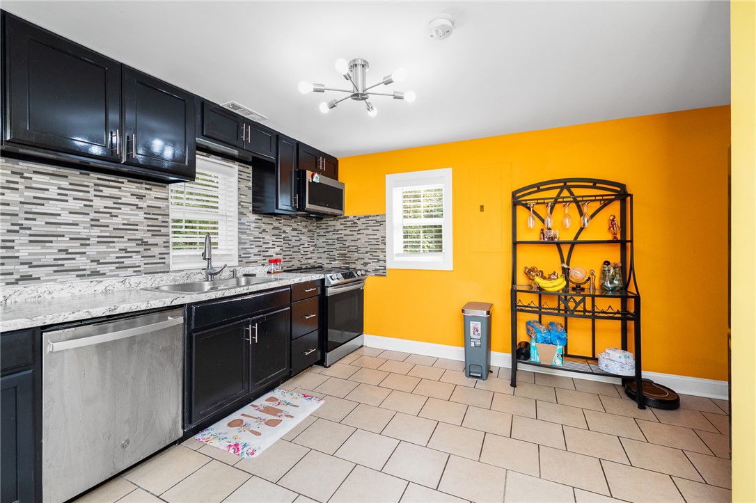 358 Finley Road Easley, SC 29642 - Photo 8 of 20 This modern kitchen features sleek black cabinetry, stainless steel appliances, and a unique backsplash.