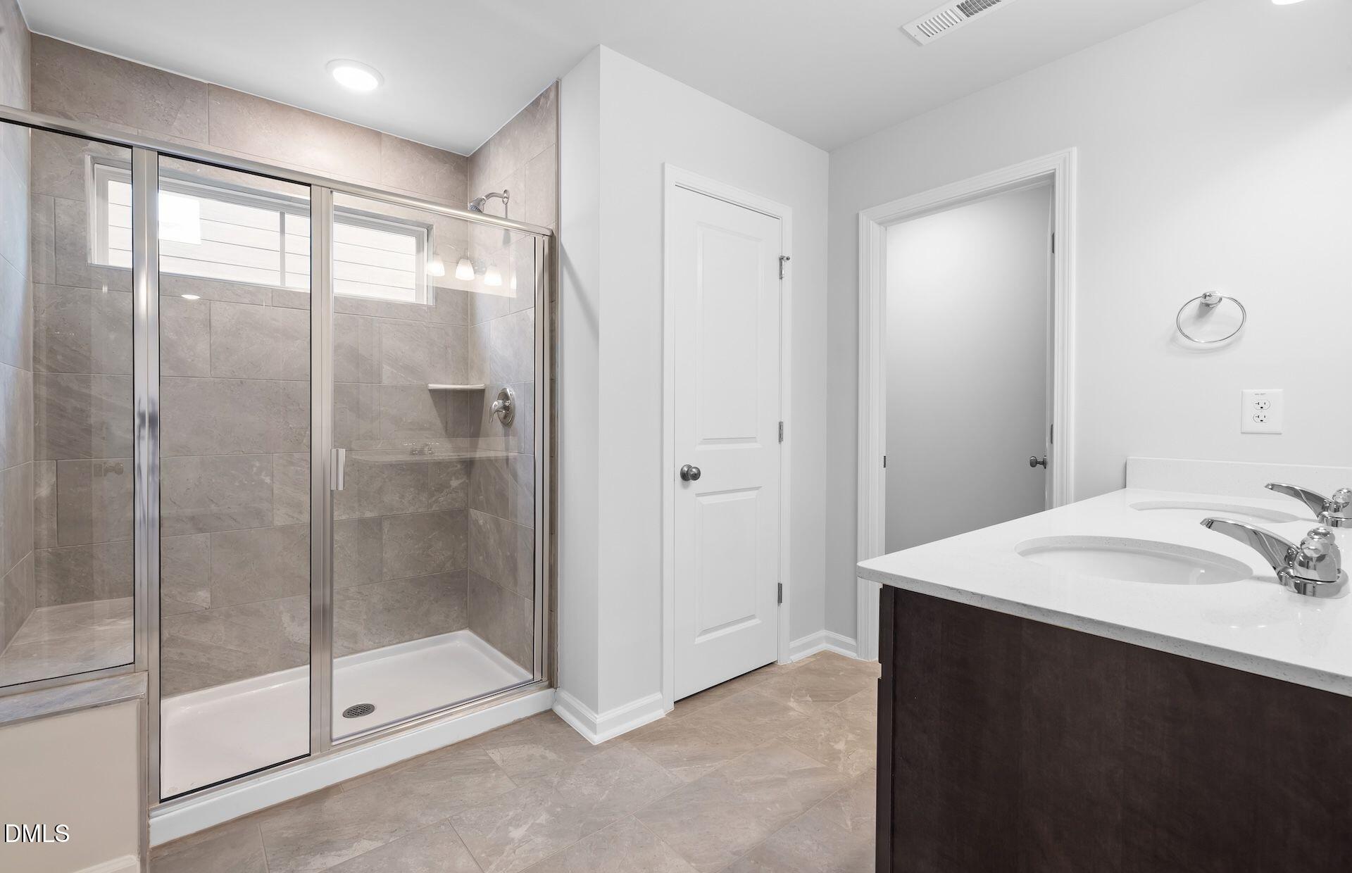 664 Ben Ledi Court Raleigh, NC 27603 - Photo 14 of 32 a bathroom with a shower sink and mirror