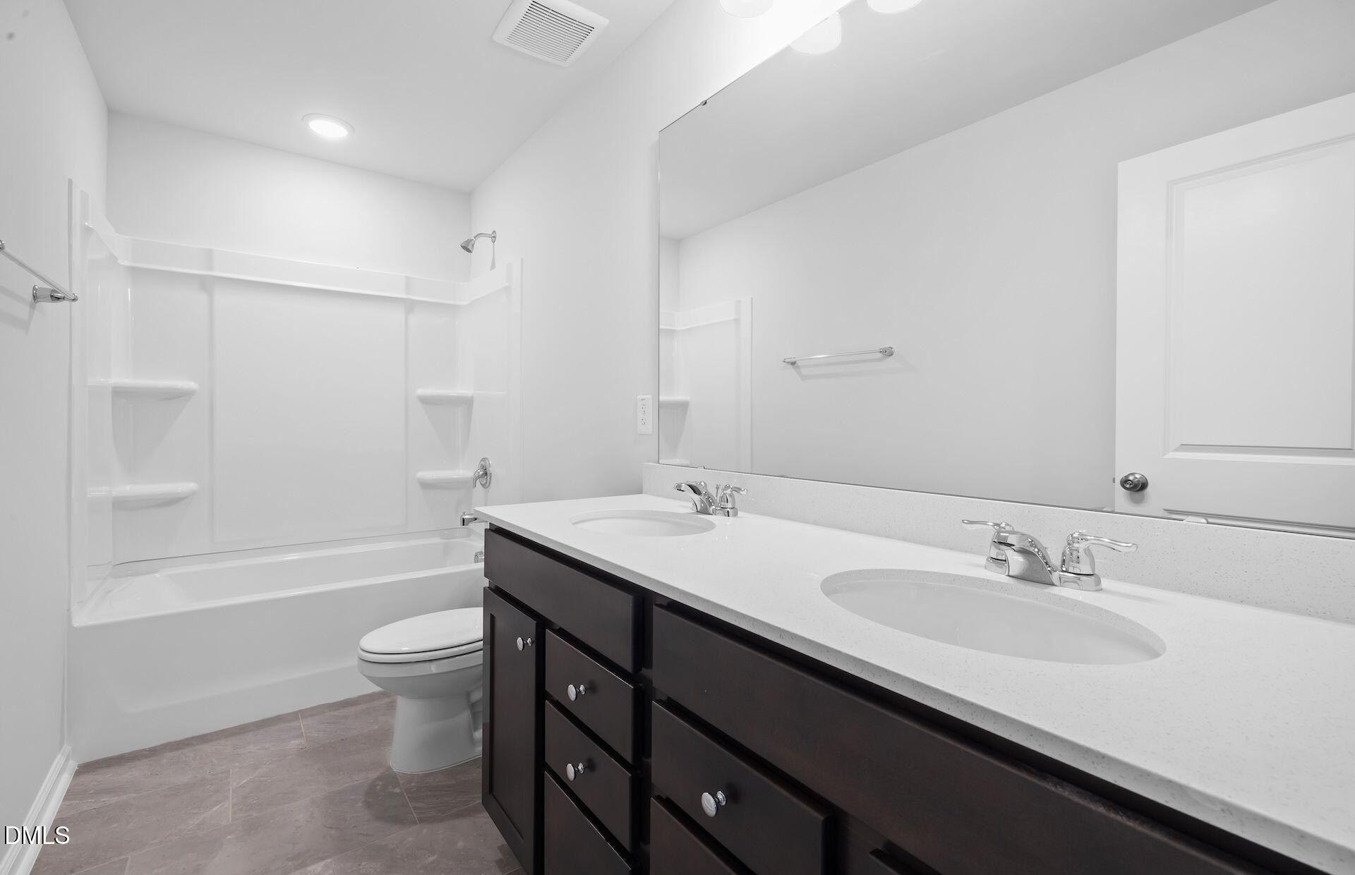 664 Ben Ledi Court Raleigh, NC 27603 - Photo 20 of 32 a bathroom with a granite countertop sink a toilet a bathtub and shower