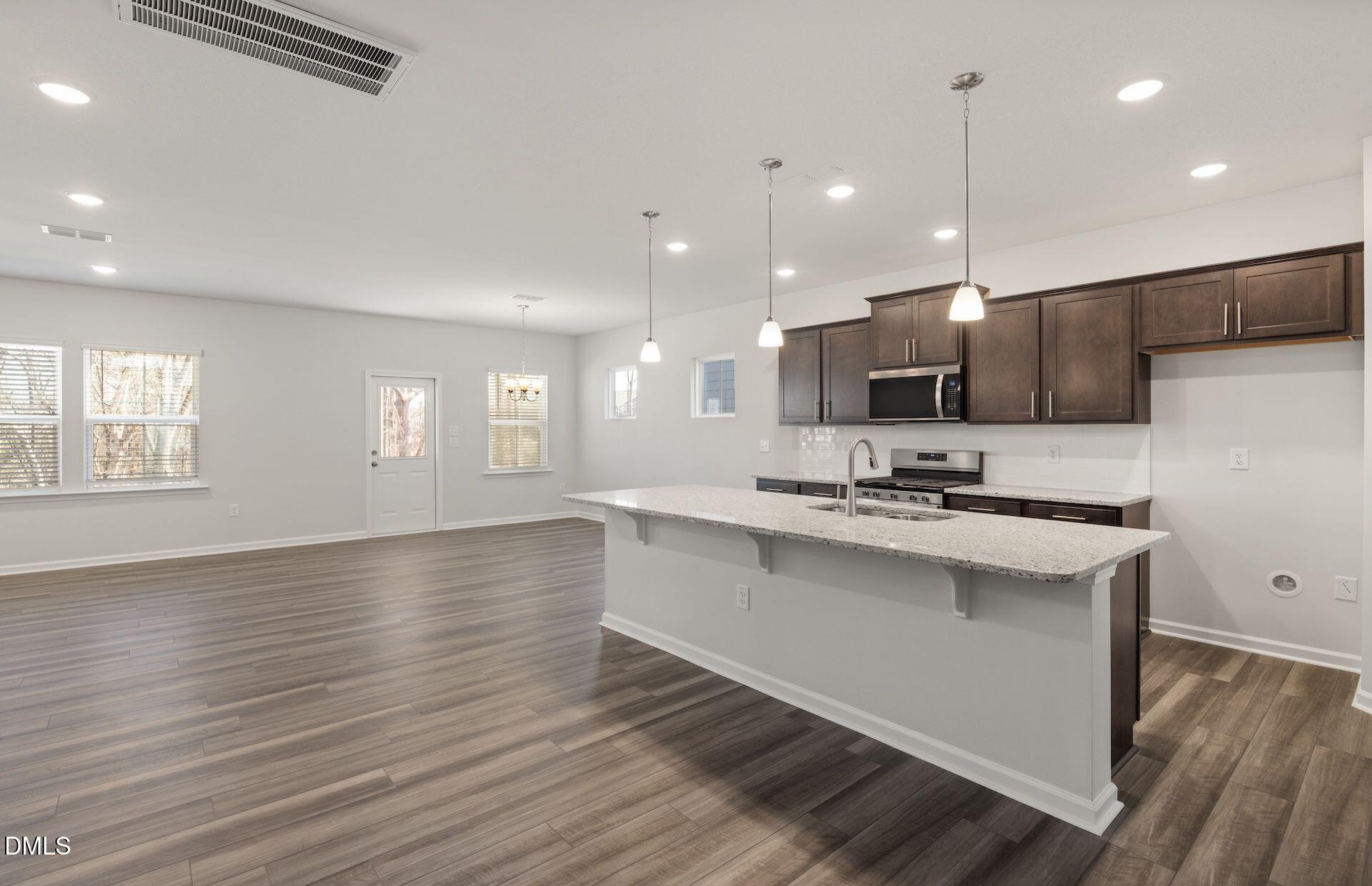 664 Ben Ledi Court Raleigh, NC 27603 - Photo 3 of 32 a kitchen with stainless steel appliances a sink stove and wooden floor