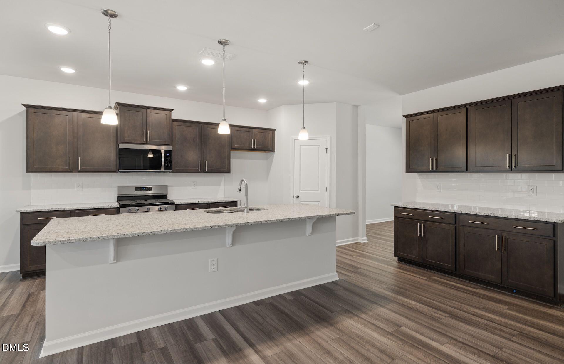 664 Ben Ledi Court Raleigh, NC 27603 - Photo 5 of 32 a kitchen with stainless steel appliances granite countertop a sink a stove and cabinets