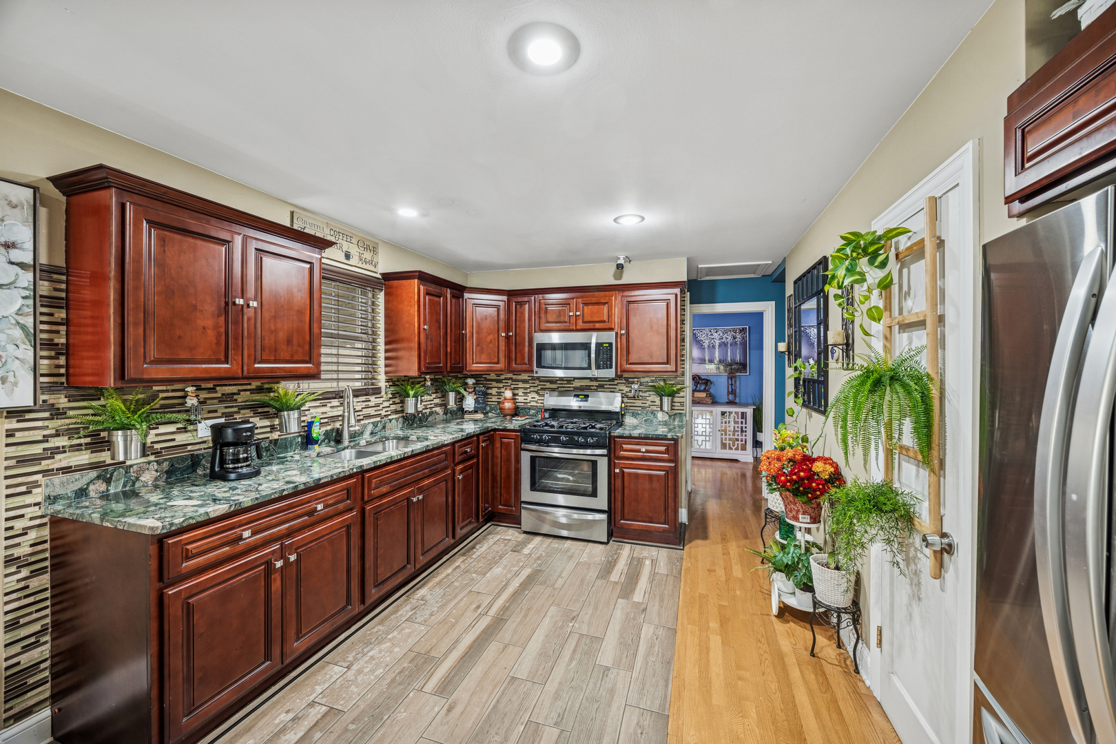 7535 West 63rd Place Summit, IL 60501 - Photo 5 of 19 a large kitchen with stainless steel appliances granite countertop a refrigerator a oven a stove and a wooden floors