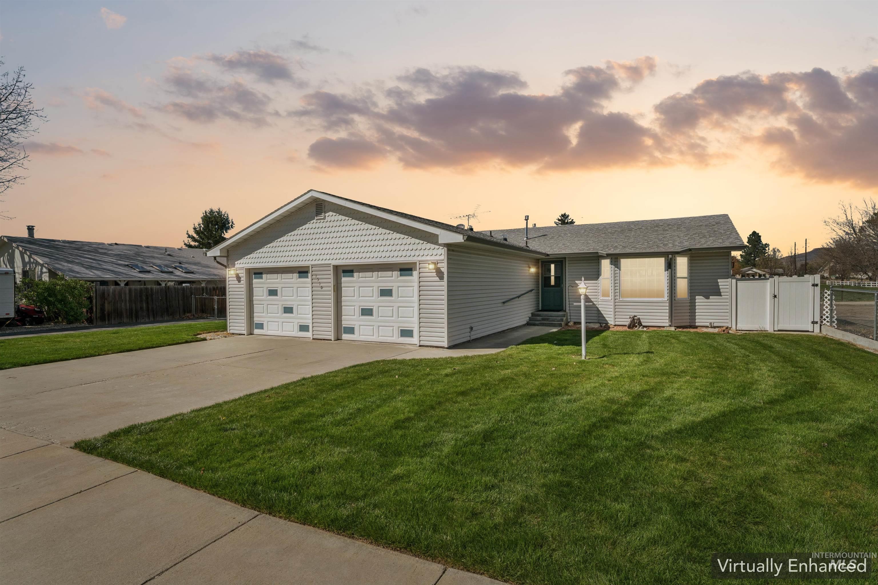 View of front of home featuring a gate, driveway, and a garage