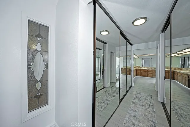 a view of a hallway with wooden floor and a living room