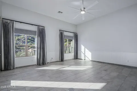 a bedroom with a bed a couch and a large window with the outer view