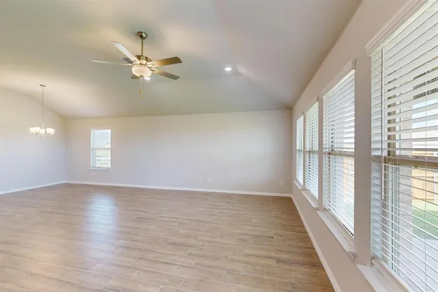 an empty room with windows and fan