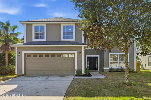 a front view of a house with a yard and garage