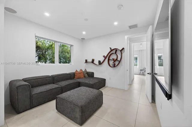 a living room with furniture a window and gym equipment