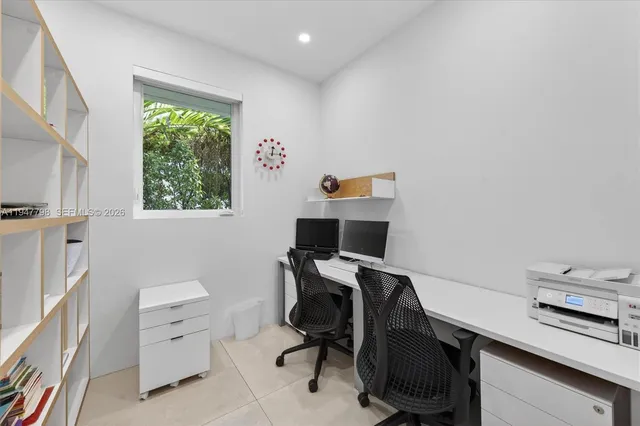 a view of a workspace with furniture and a window