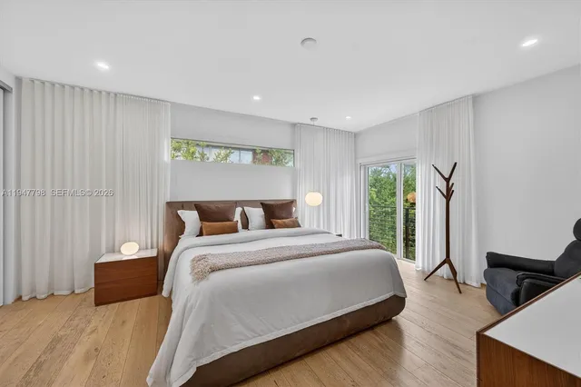 a bedroom with a large bed and a flat tv screen on dresser