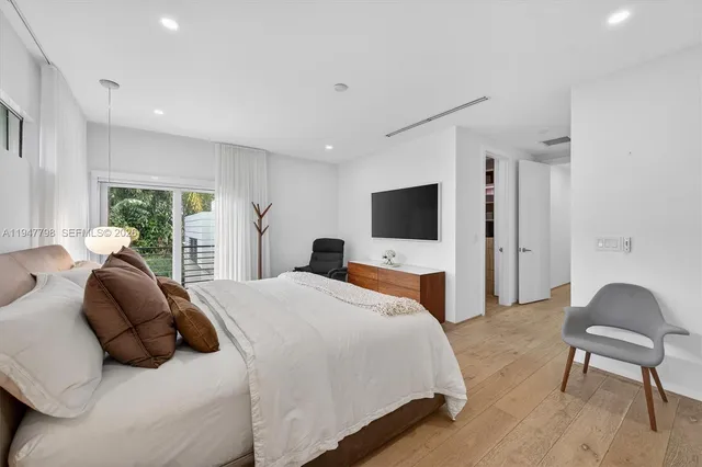 a spacious bedroom with a bed and a flat screen tv