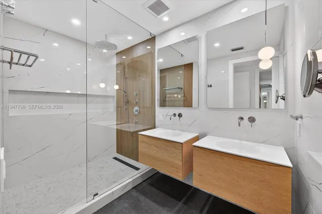 a bathroom with a double vanity sink mirror and shower