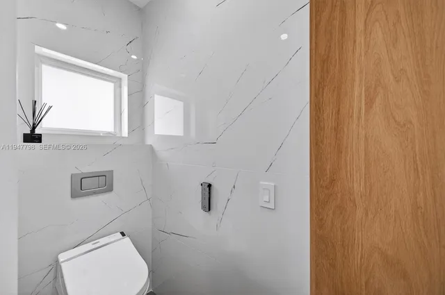 a bathroom with a toilet a sink and mirror