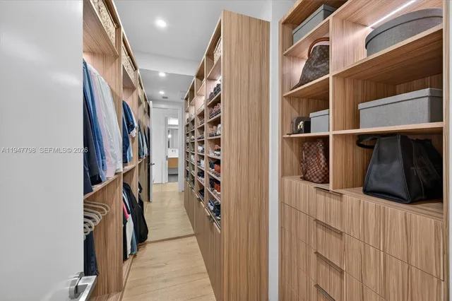 a view of walk in closet with clothes and shoes