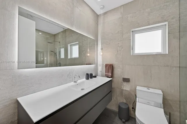 a bathroom with a toilet sink and mirror