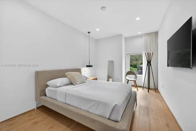 a bedroom with a bed and a flat screen tv