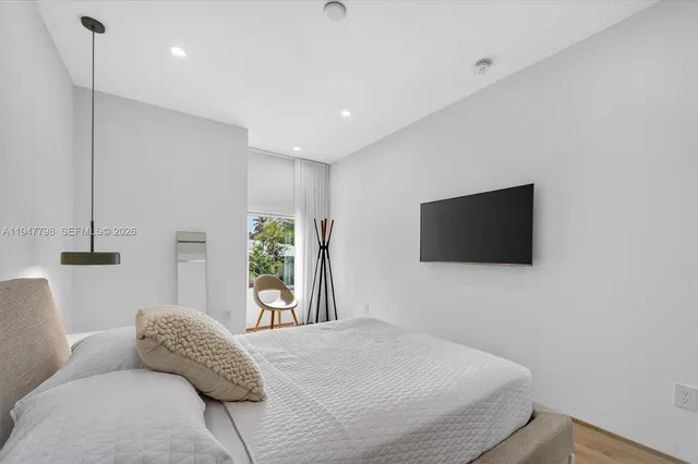 a bedroom with a bed and a flat screen tv