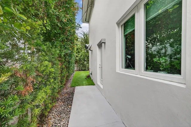 front view of house with a yard and palm trees