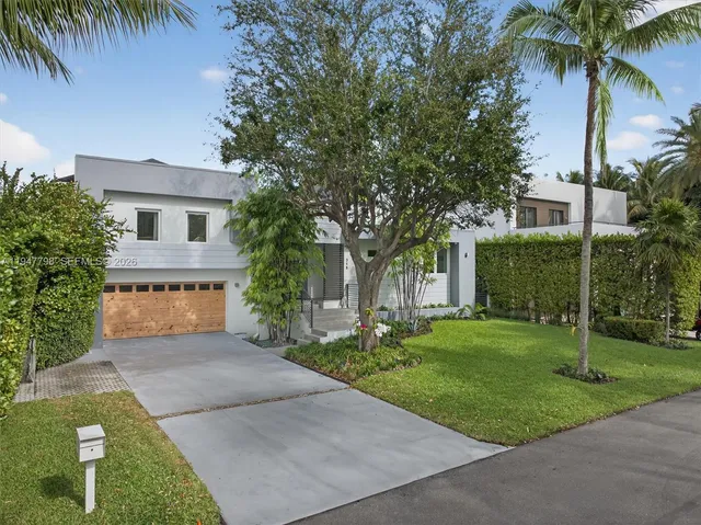 a house with a big yard plants and large trees