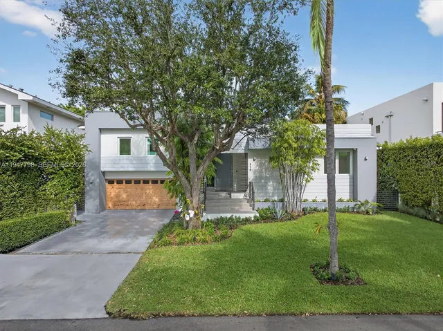 a house with a big yard and palm trees