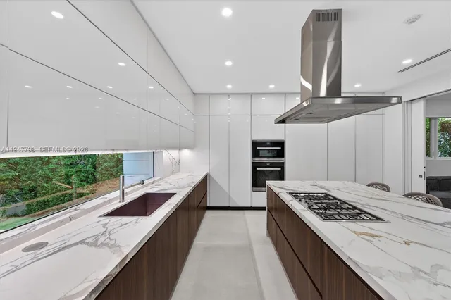 a large kitchen with stainless steel appliances kitchen island a large counter top a stove and a refrigerator