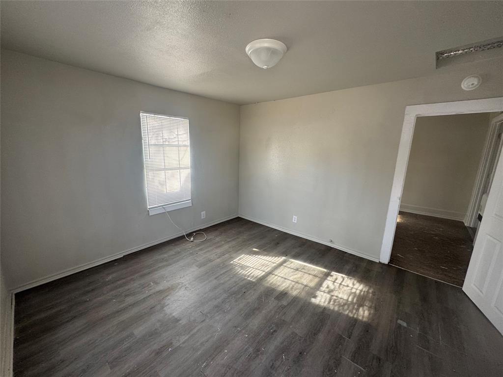 2410 Clinton Street Abilene, TX 79603 - Photo 7 of 7 an empty room with wooden floor and windows