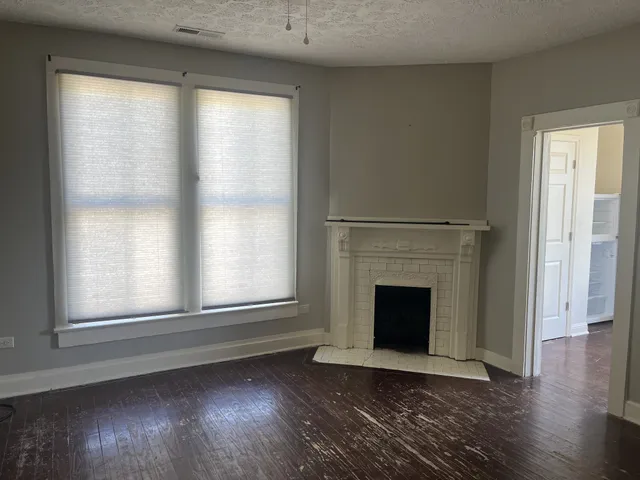 wooden floor fireplace and windows in an empty room