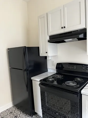 a close view of a stove a refrigerator and cabinets