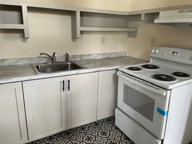 a kitchen with white cabinets and white appliances