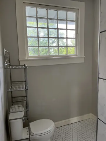 a white toilet sitting next to a window