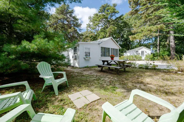 a view of swimming pool with lawn chairs and plants