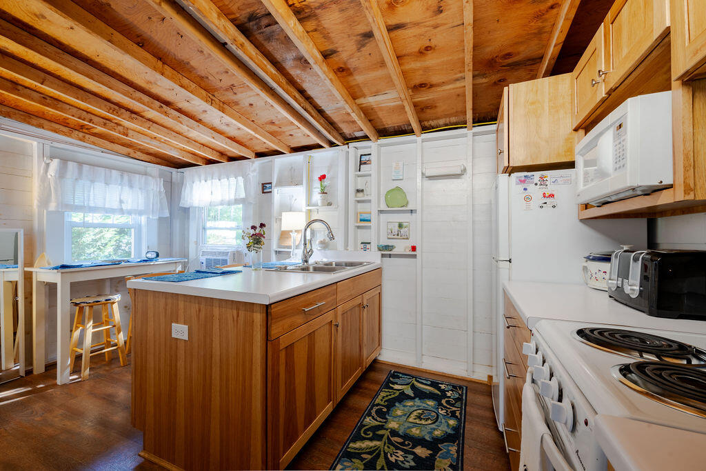 1937 State Highway Route 6, Unit E Eastham, MA 02642 - Photo 6 of 20 a kitchen with granite countertop a stove and a refrigerator