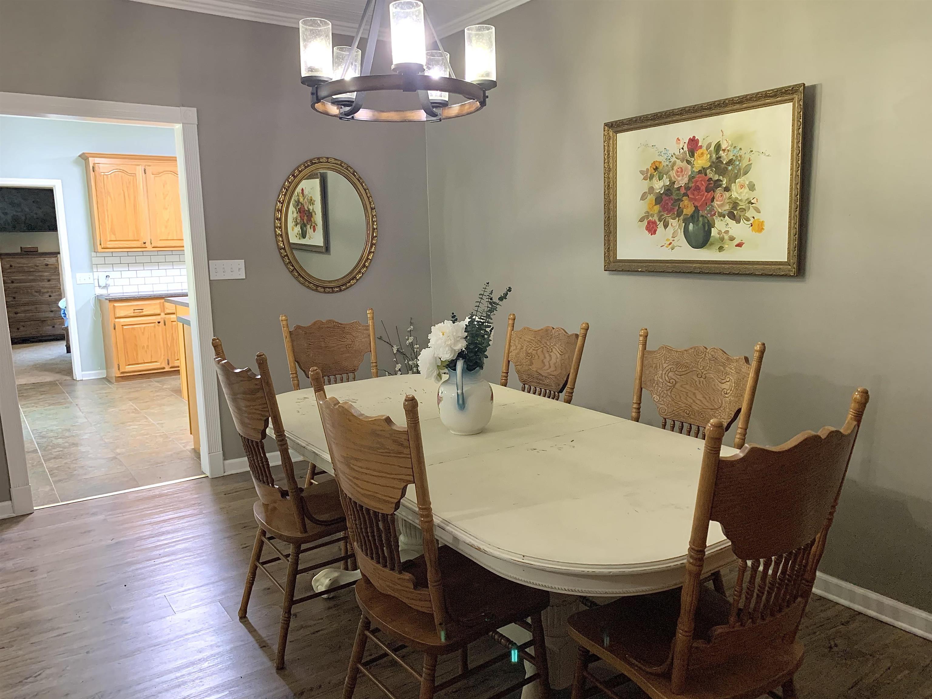 7675 Peavine Road Middleton, TN 38052 - Photo 11 of 26 a view of a dining room with furniture a chandelier and wooden floor