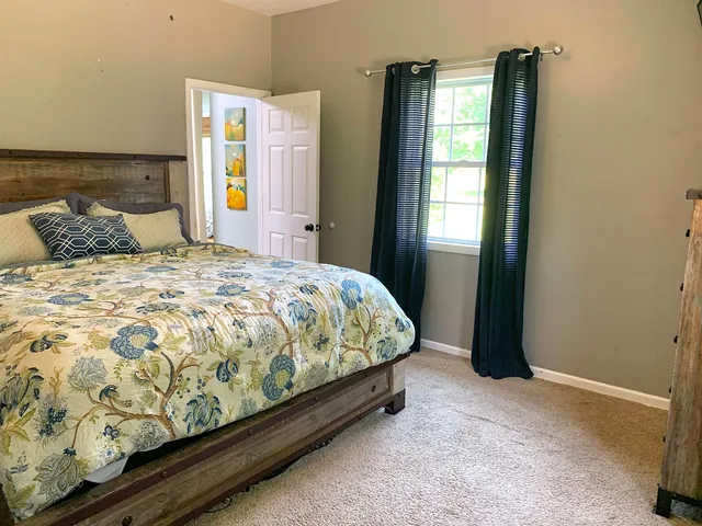 a large bed sitting in a bedroom next to a window
